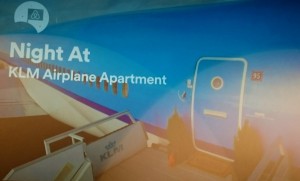 A picture of a presentation slide from Beat the Buzz, showing the side of a bright blue aeroplane with the words "Night At KLM Airplane Apartment" superimposed on top in white font.