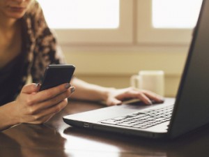 woman on phone and laptop