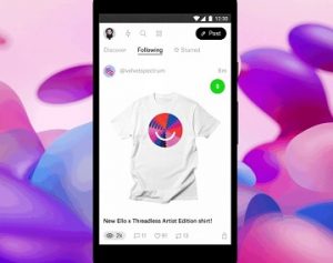 A black smartphone against a purple and pink background, displaying T-shirt for sale on Ello with a colourful version of the Ello smiley face logo on its front, and a green dollar sign in the upper right corner.