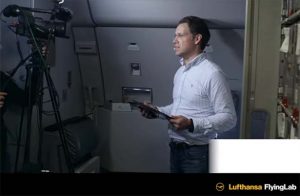 The image shows Dr. Wingenter presentation being filmed and streamed live to the devices of FlyingLab passengers.