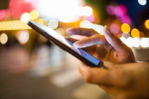 Woman using her Mobile Phone, Night Light Background